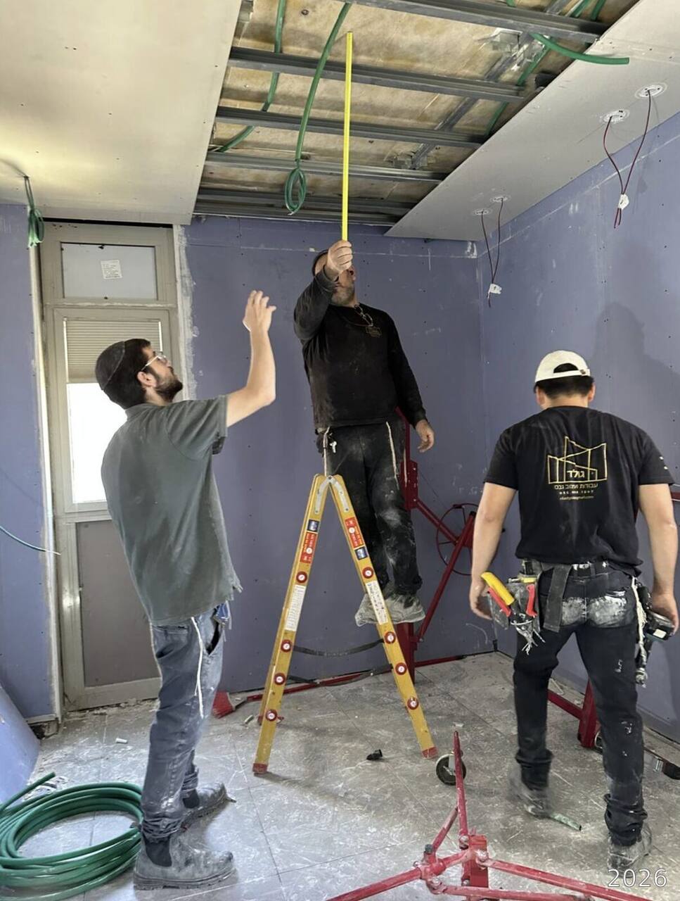 Hanging drywall panels on the ceiling