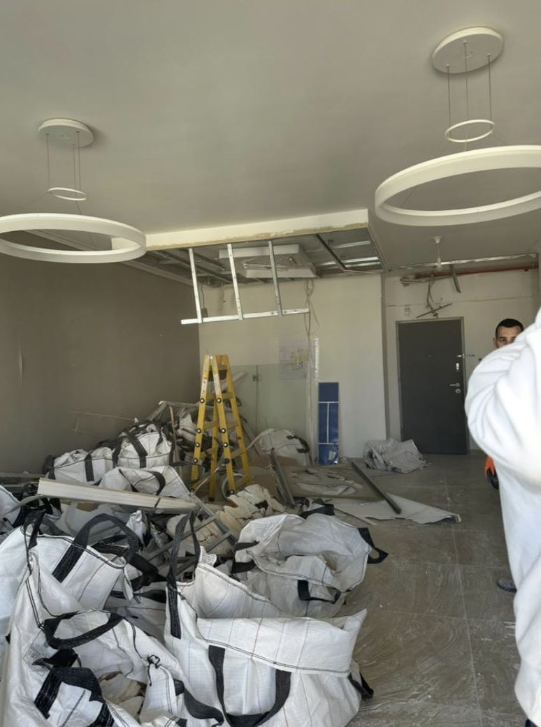 Worker clearing debris near the reframed windows