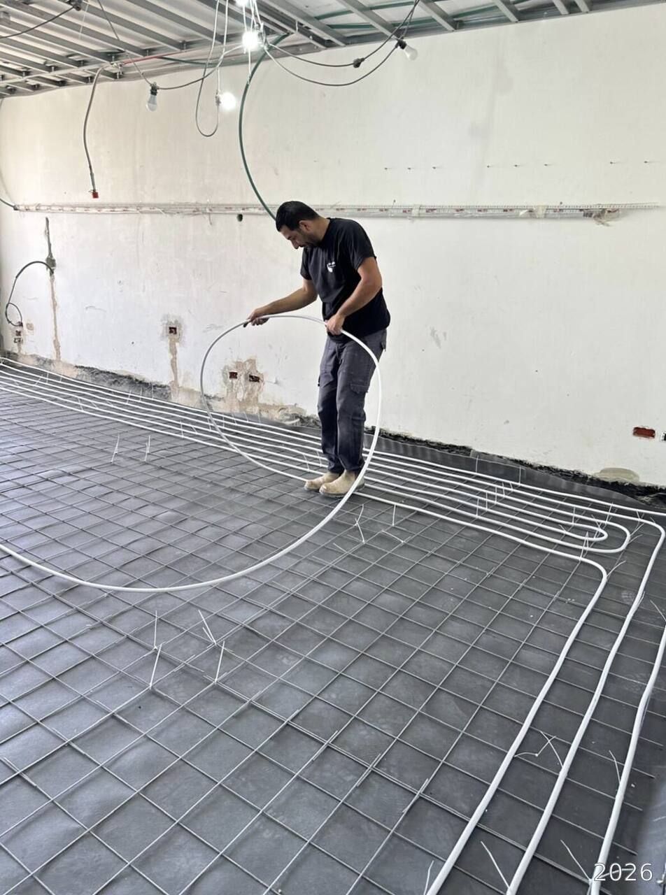 Worker laying a floor heating loop