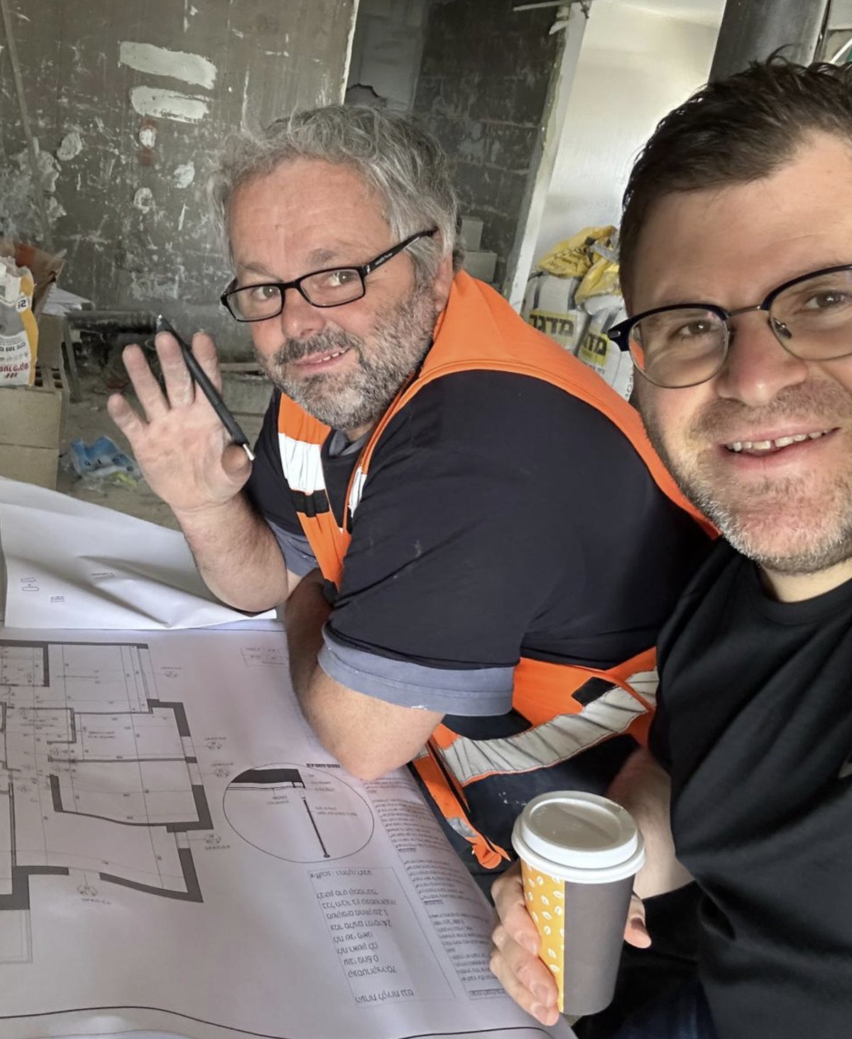 Aryeh Rapaport reviewing renovation plans on site with a contractor