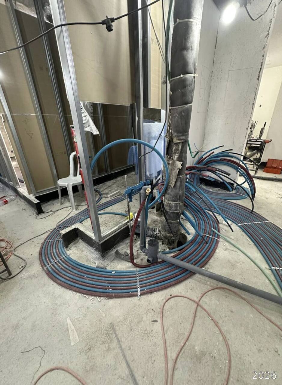 Plumbing supply lines routed across the floor