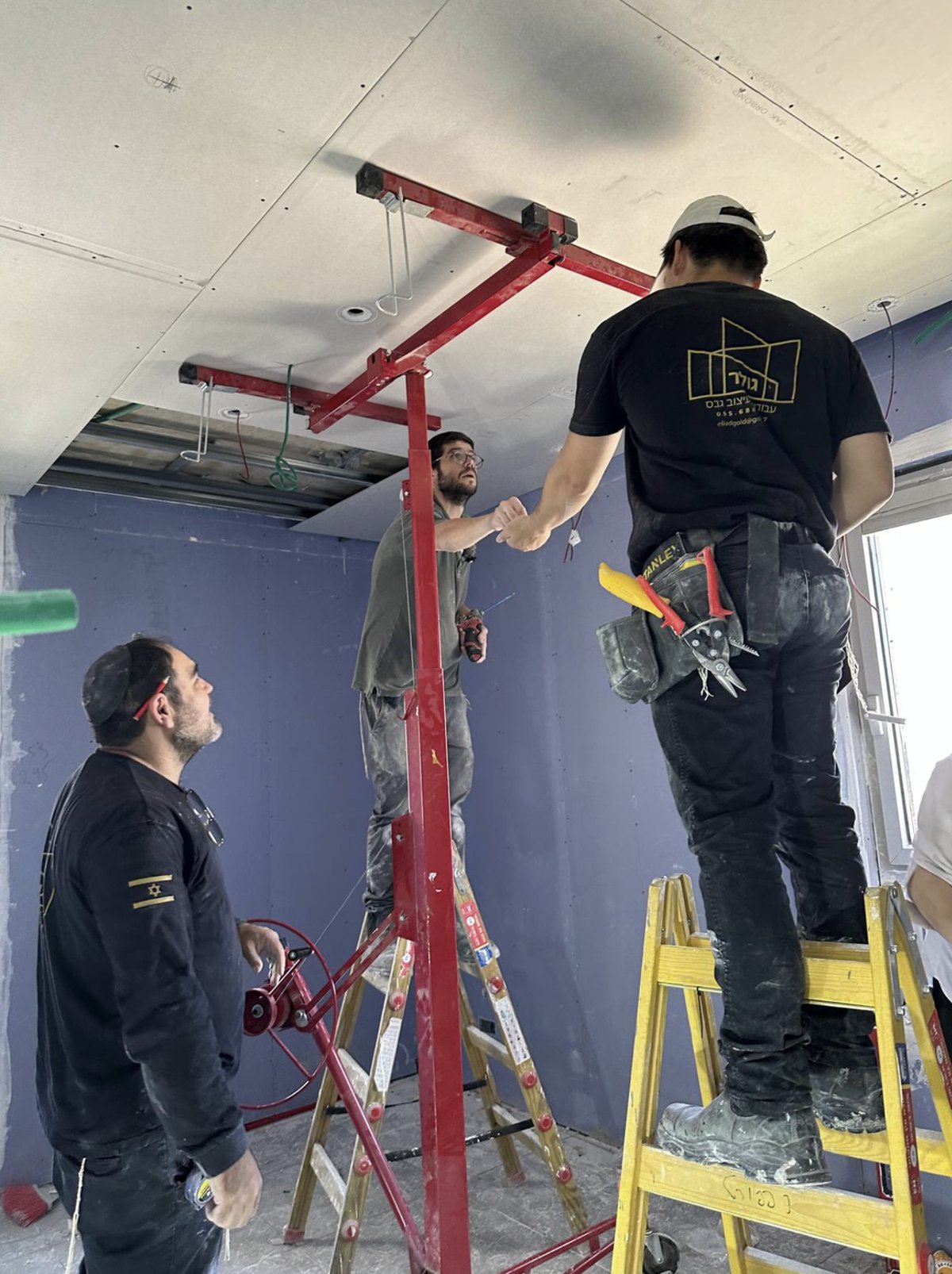Crew installing an overhead ceiling track during a renovation
